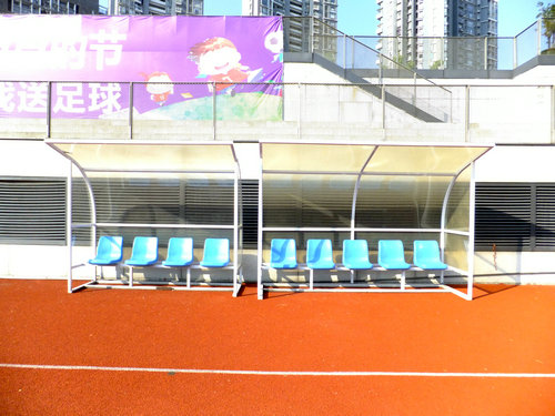 实拍深圳宝安体育馆足球场景观，有工人在维护有市民在跑步