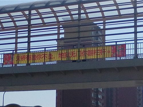 长春亚泰大街天桥挂惊悚标语“地狱无门翻栏杆”引争议