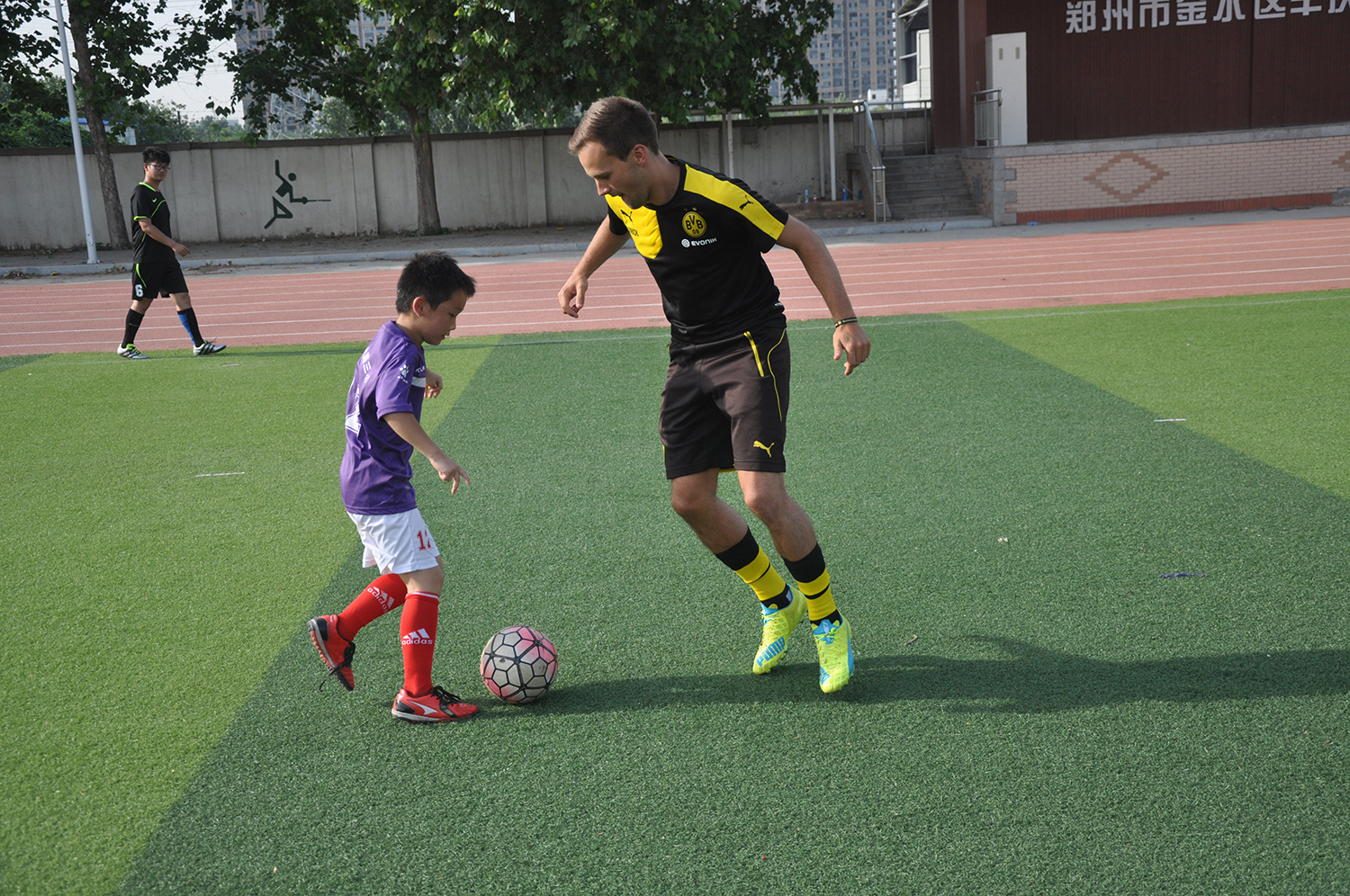 当教练蹲下来以孩子的视线去阅读比赛多特蒙德青训教练在金水