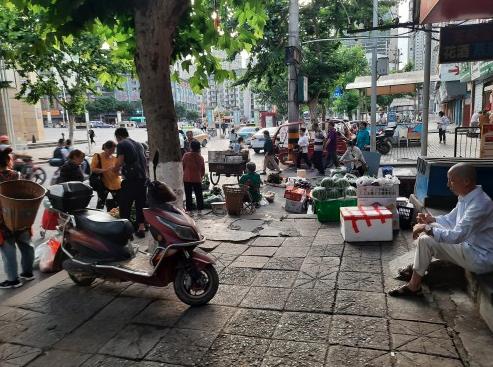 七星农贸市场临时摆摊,七星城管整治占道乱堆物料现象