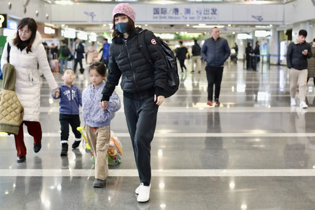 梅婷带孩子走机场,48岁梅婷黑色羽绒服配打底裤